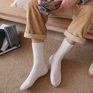 Detailed knit texture of men wool crew socks featuring classic argyle pattern and ribbing