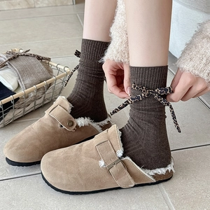 Detail of knit socks with leopard bow and brown clogs with faux fur lining