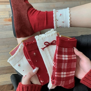 Detailed close-up of vintage floral red wool socks with bow accents and retro plaid patterns