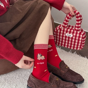 Détail de chaussettes rouges festives avec broderie cheval mignon et motifs dorés