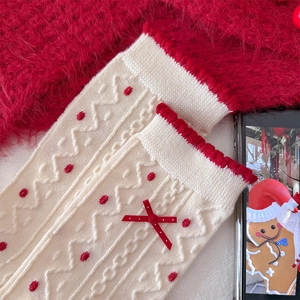 Detail of wool socks with festive red polka dots, bow accent and scalloped edge