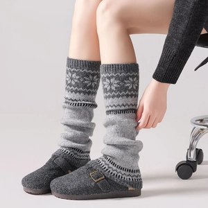 Close-up of Fair Isle snowflake pattern knit leg warmers with grey buckle clogs
