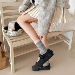 Detail of dark grey wool Mary Jane flats with hook-and-loop strap and cozy knit socks