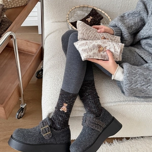 Detailed view of warm winter socks with bear embroidery and cozy grey platform clogs