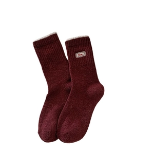 Thick burgundy wool socks with polka dot pattern and a Nice tag for winter warmth