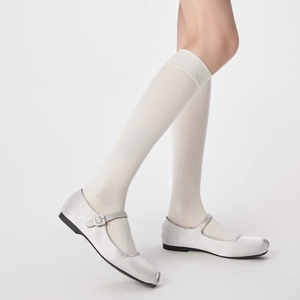 Close-up of white ribbed wool socks paired with silver Mary Jane shoes for a stylish look