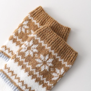 Close-up of thick Fair Isle knit leg warmer with snowflake patterns and ribbed cuff detail