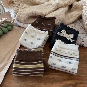 Detailed macro view of retro floral knit wool socks with ruffle edges and bow accents