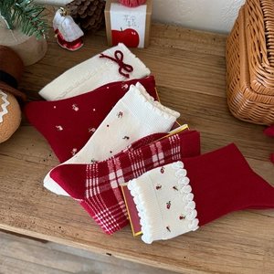 Detail of five pairs of red and white Christmas wool socks with bows and floral patterns