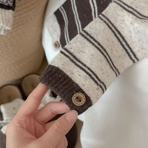 Detail of wool socks with colorful nep yarn stripes and decorative button on cuff