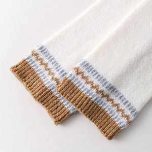 Macro view of Fair Isle knit leg warmers showing soft snowflake texture and ribbed cuffs