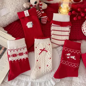 Detailed flat lay of red and white Christmas wool socks with holiday patterns and bows