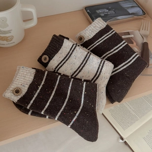 Detailed knit texture of wool socks with wooden buttons and colorful speckled yarn