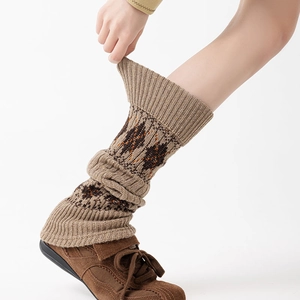 Detail showing elastic knit texture and ethnic geometric patterns on the leg warmers