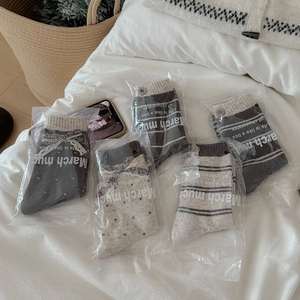 Detail of five pairs of warm wool blend socks with bow and button accents in a gift pack