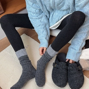 Detailed close-up of thick contrast wool socks with plush trim and knit texture