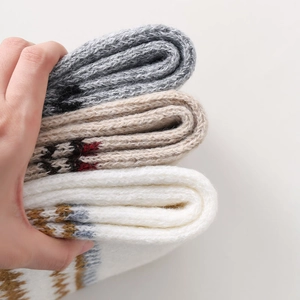 Close-up of thick Fair Isle knit leg warmers showing ethnic snowflake patterns and texture