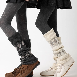 Macro detail of knitted argyle leg warmers in charcoal and cream for winter styling