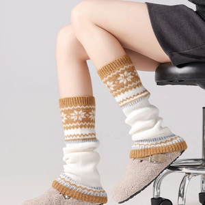 Detail of Fair Isle snowflake pattern on yellow and white knitted leg warmers