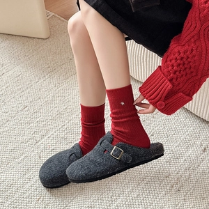 Close-up of wool mule slipper with warm fleece lining and stylish red knit socks