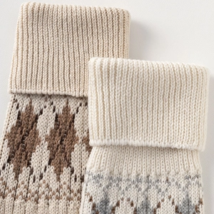 Close-up of wool blend knit leg warmers with geometric jacquard patterns and ribbed edges