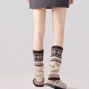 Detail of Nordic Fair Isle knit leg warmers with snowflake pattern and thick warm texture