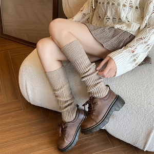 Scaldamuscoli in maglia a righe verticali abbinati a scarpe marroni con plateau invernali