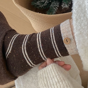 Detail of wool socks featuring wood buttons, color stripes and colorful nep yarn texture