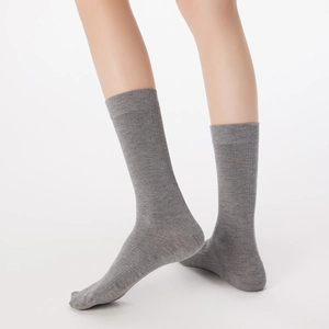 Close-up of gray ribbed mid-calf socks with elastic cuffs and detailed wool texture