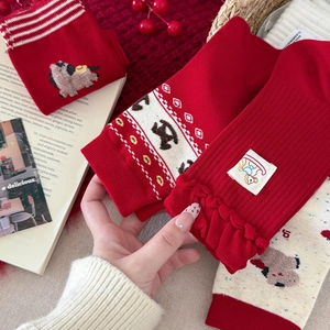 Détails de chaussettes rouges festives avec broderie et volants en décor de cadeau
