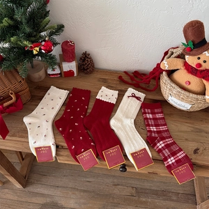 Detailed set of floral and plaid wool socks displayed with festive holiday decor