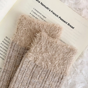 Detailed view of plush fuzzy cuffs and ribbed knit texture on warm winter socks