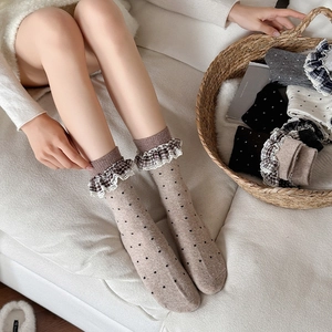 Detail of wool socks featuring black polka dots and vintage plaid lace trimming accents