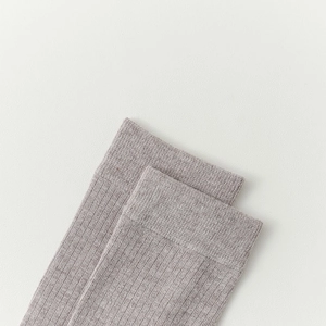 Close-up of high-quality grey knit wool socks featuring elastic ribbed cuff detail