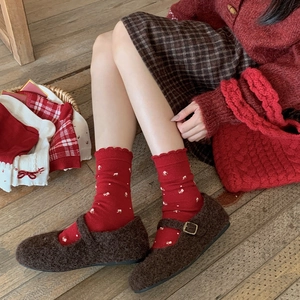 Detail of red floral knit wool socks paired with vintage brown velvet Mary Jane flats
