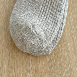 Macro detail of thick wool socks showing premium knitted texture and smooth seam stitching