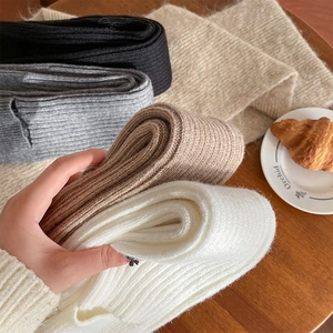 Primo piano di scaldamuscoli in maglia a costine in nero, grigio, kaki e bianco crema