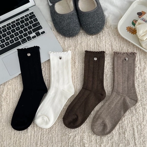 Detail view of four-color ribbed socks with ruffle edges and metallic accents