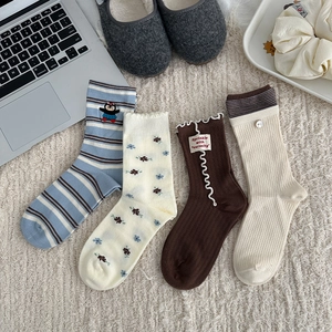 Detailed flat lay of diverse floral and striped cotton crew socks with cute embroidery