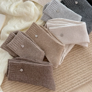 Detail of wool knit socks showing ribbed texture and small silver metal button accents