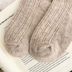 Macro detail of thick ribbed wool knit socks on an open book for winter warmth