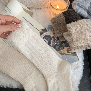 Detail of plush knitted wool socks in earthy tones on soft faux fur with home decor
