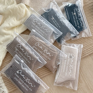 Close-up of thick knitted wool socks in earthy tones with zipper bag packaging
