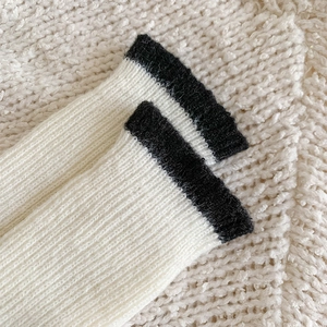 Detailed macro shot of thick ribbed knit fabric on warm white wool socks with black stripes