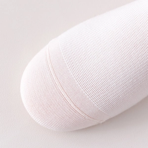 Macro shot of fine knit texture and reinforced seam on light pink cotton knee-high socks