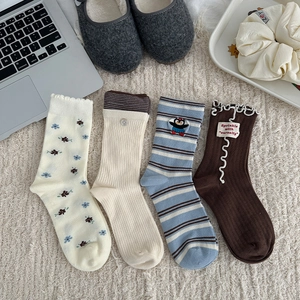Flat lay of vintage floral mid-calf socks with cute embroidery and ruffled edges