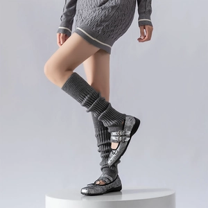 Detail of grey ribbed knit leg warmers styled with silver metallic Mary Jane shoes