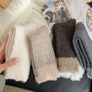 Close-up of four pairs of thick winter socks with cozy faux fur lining and knit texture