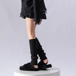 Vertical ribbed black leg warmers styled with fluffy faux fur slippers on a white stand