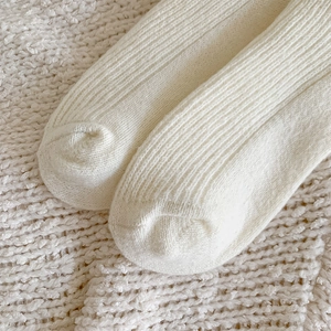 Close-up of knit texture and seamless toe stitching on warm beige thermal socks